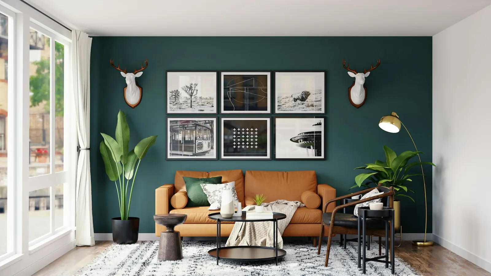 Living room with a deep green wall, framed prints and a tan leather sofa